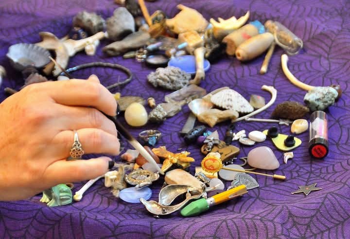 A hand working with bones and curios during a reading